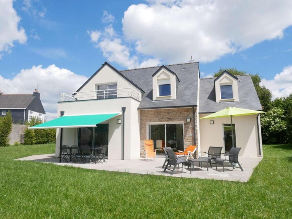 une maison avec un patio avec des chaises et une table dans l'établissement Villa contemporaine à Belz - 4 chambres, jardin - FR-1-479-212, à Belz