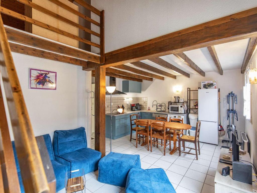 une cuisine et un salon avec des chaises bleues et une table dans l'établissement Chalet idéal au cœur de Cauterets, 6-8 pers, parking privé - FR-1-401-315, à Cauterets
