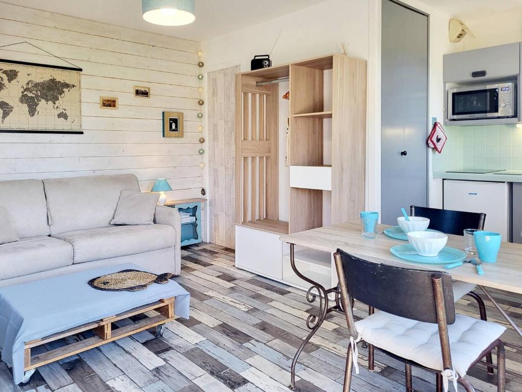 un salon avec un canapé et une table dans l'établissement Studio avec parking à 2 pas de la plage, Merville-Franceville - FR-1-788-54, à Merville-Franceville-Plage