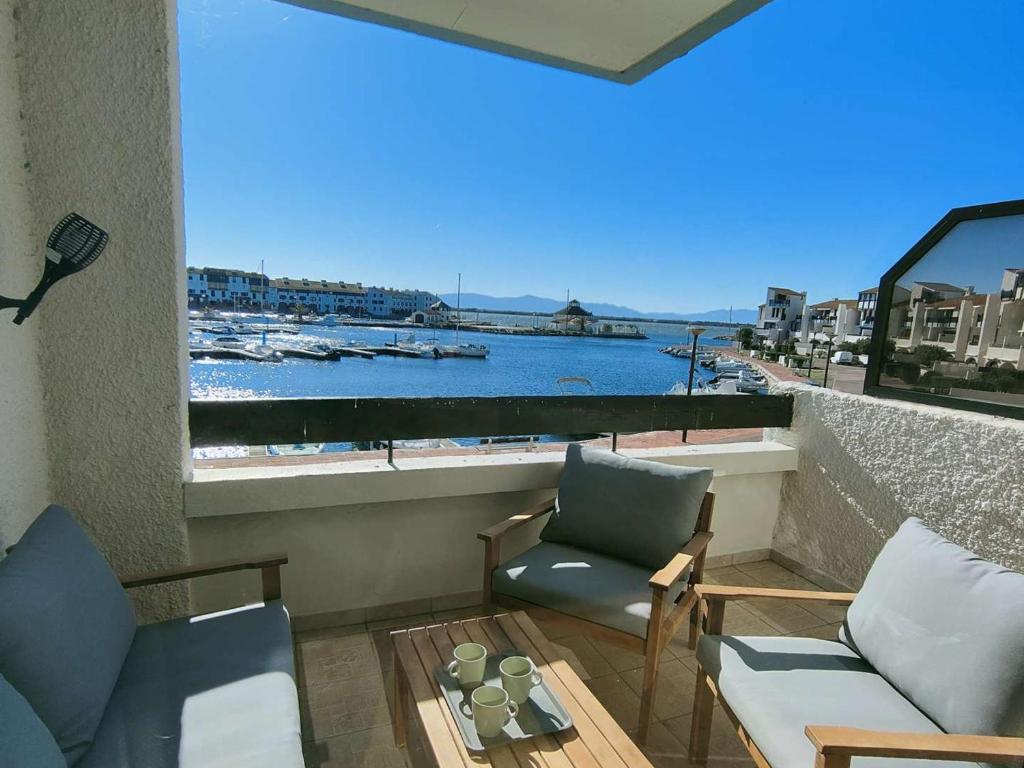 d'un balcon avec vue sur le port doté d'un canapé et de chaises. dans l'établissement T2 charmant - 4 pers - Terrasse avec vue sur port - FR-1-195-113, au Barcarès