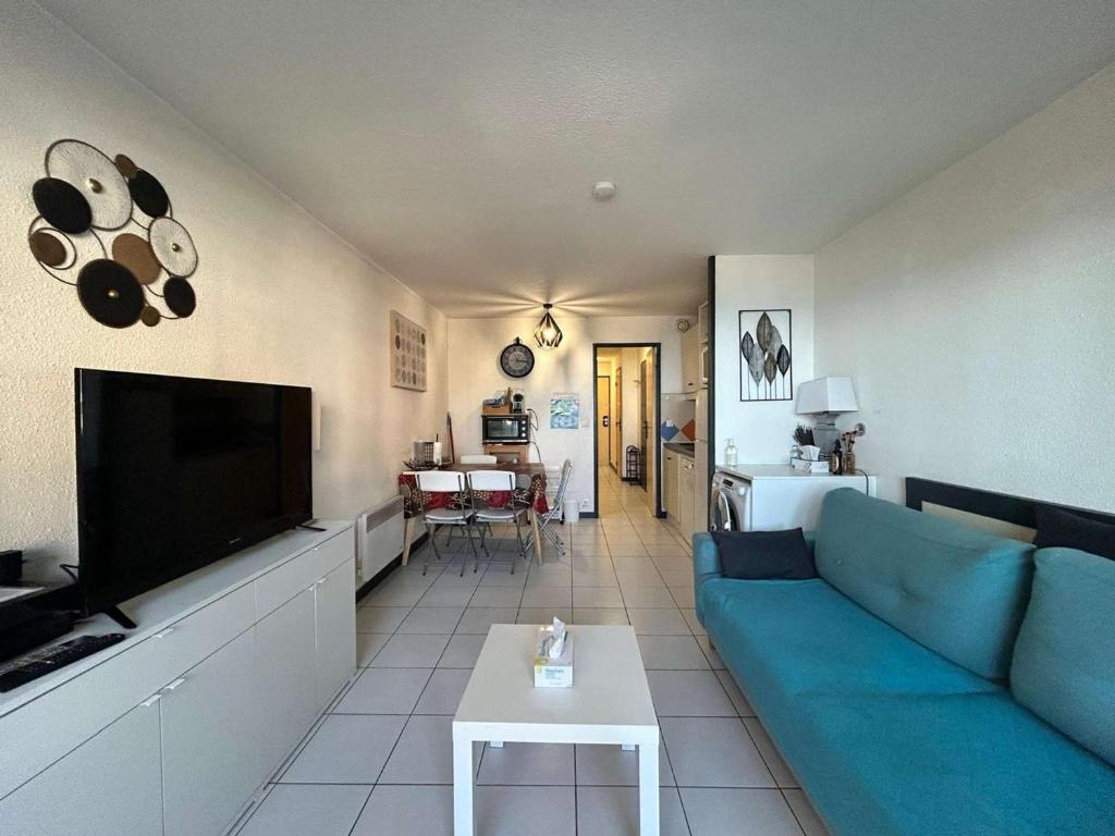 un salon avec un canapé bleu et une télévision dans l'établissement Appartement Cannes la Bocca proche plage - FR-1-609-109, à Cannes