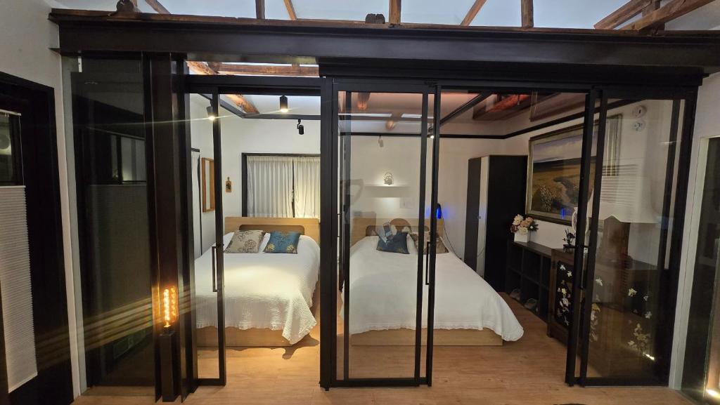 ein Schlafzimmer mit einem Bett in einem Zimmer mit Glastüren in der Unterkunft Jian Hanok in Seoul