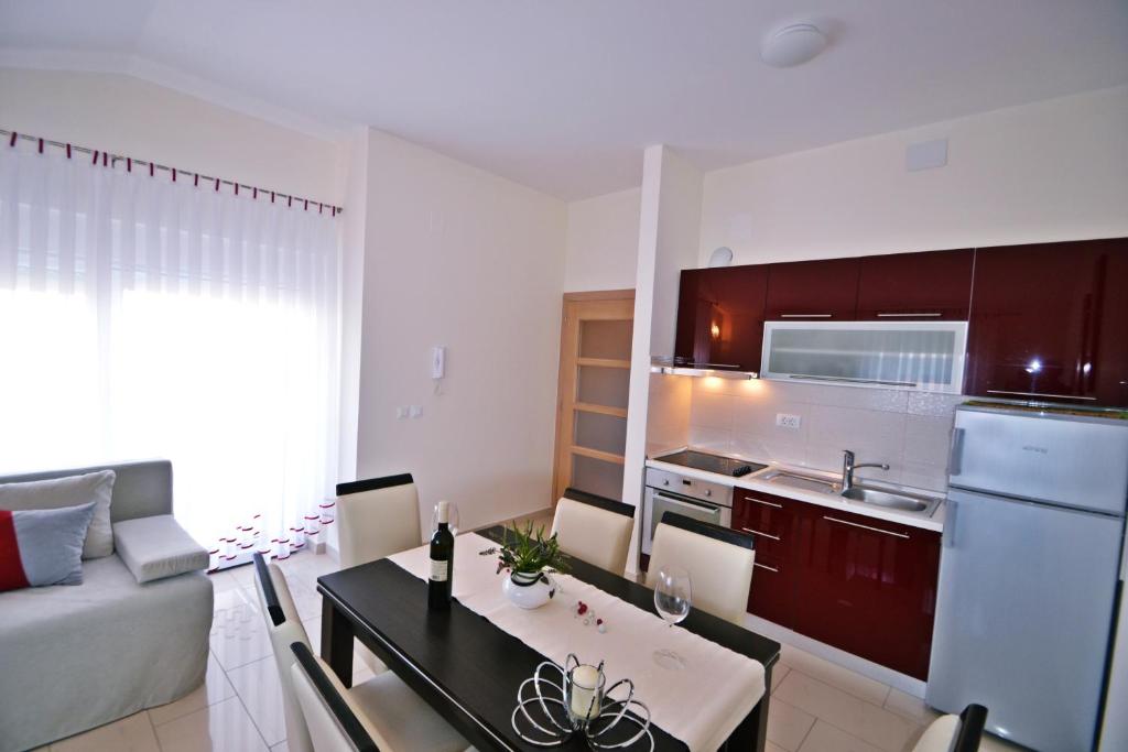 a kitchen and living room with a table and a couch at Apartments Ivana in Sveti Filip i Jakov