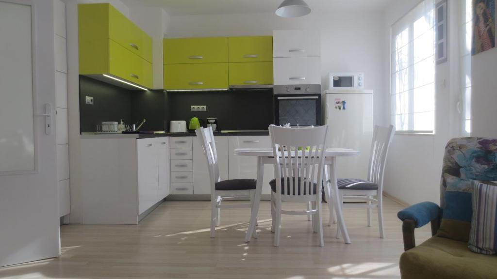 una cocina con armarios verdes, mesa y sillas en Apartment Sophie, en Plovdiv