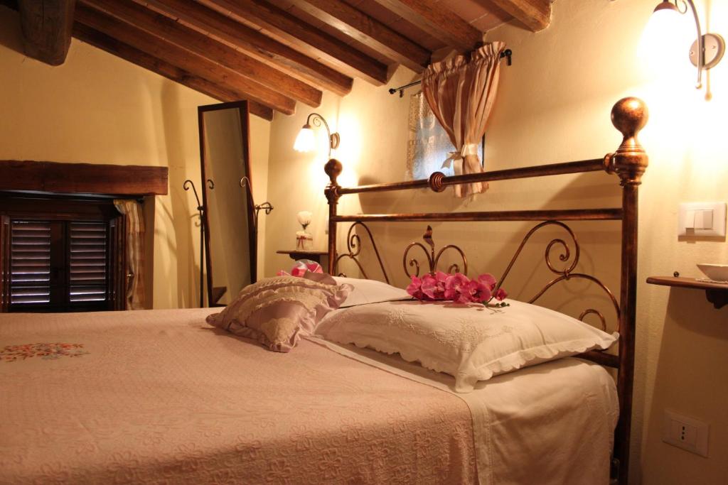 una camera da letto con un grande letto con fiori rosa di Casa Vacanze Le Antiche Pietre a Ortignano Raggiolo