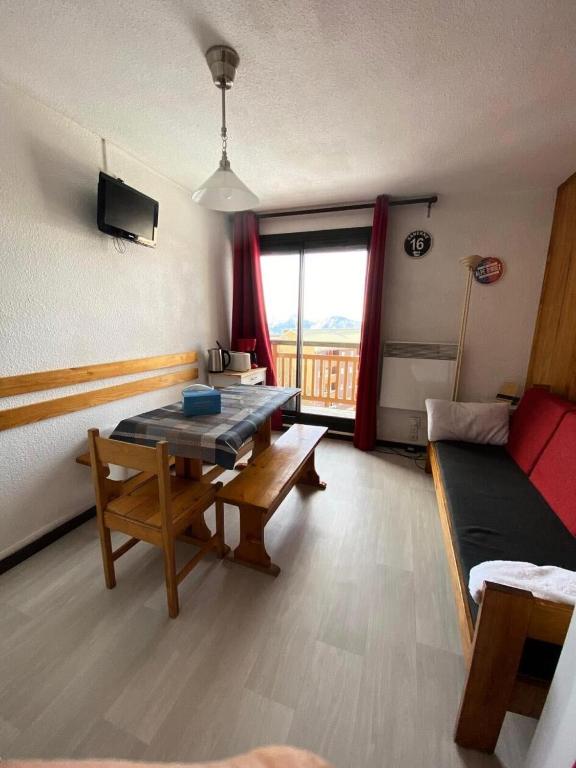 un salon avec une table et un canapé dans l'établissement Studio 4 pers Soleil d'Huez - maeva Home - Studio 4 Personnes Confort MAE-5688, à L'Alpe-d'Huez