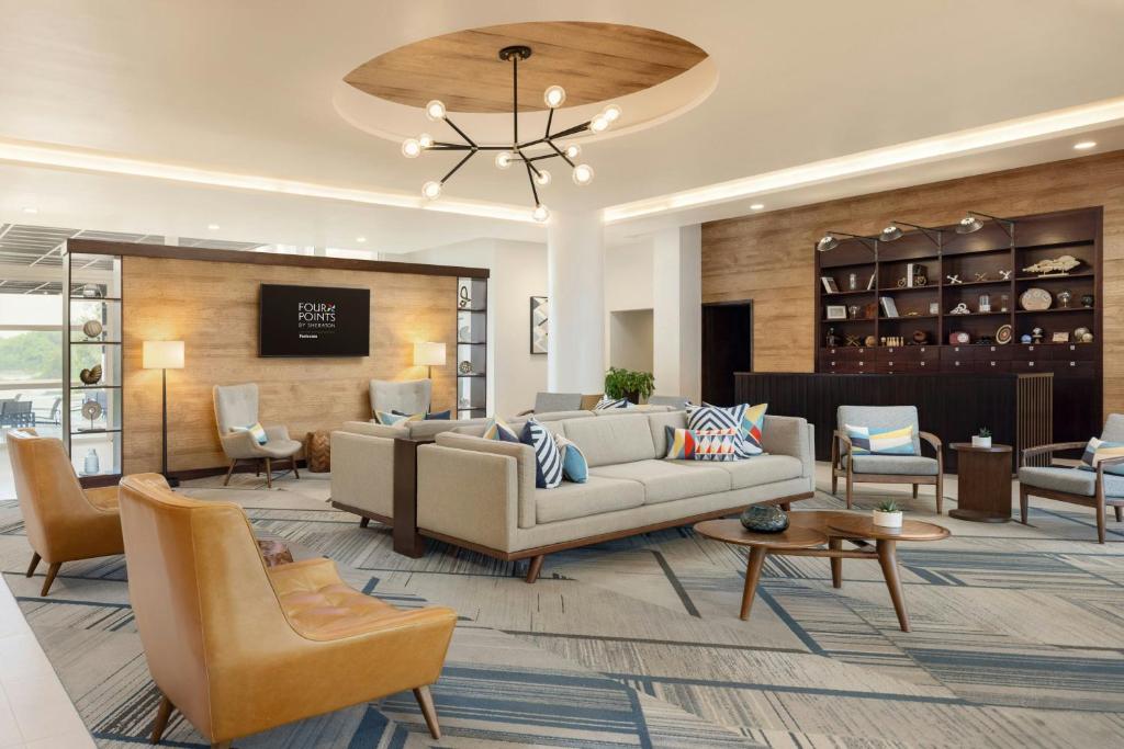 vestíbulo con sofá, sillas y mesa en Four Points by Sheraton , en Punta Cana