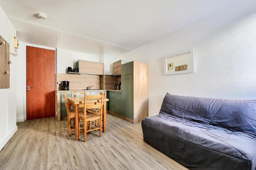 un salon avec un canapé et une table et une cuisine dans l'établissement Résidence Le Tourmalet - maeva Home - Studio 4 personnes - Prestige MAE-0501, à La Mongie