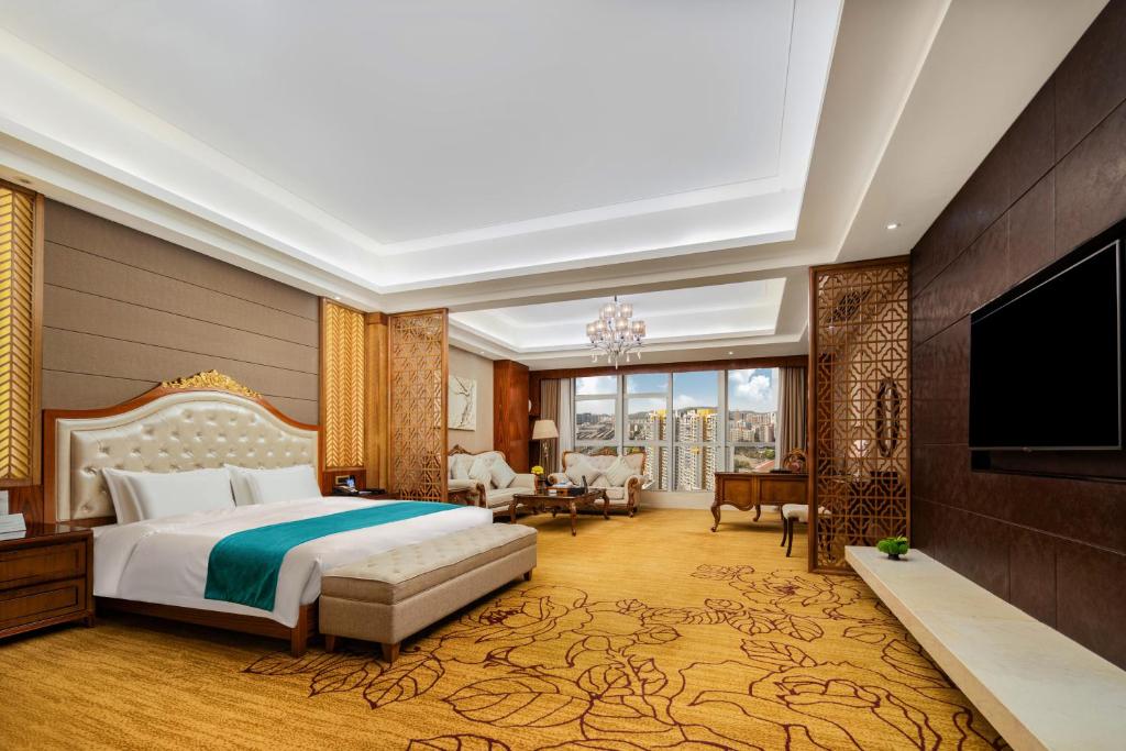 a hotel room with a bed and a flat screen tv at Honder International Hotel - Free shuttle bus between hotel and exhibition center during Canton Fair period in Guangzhou