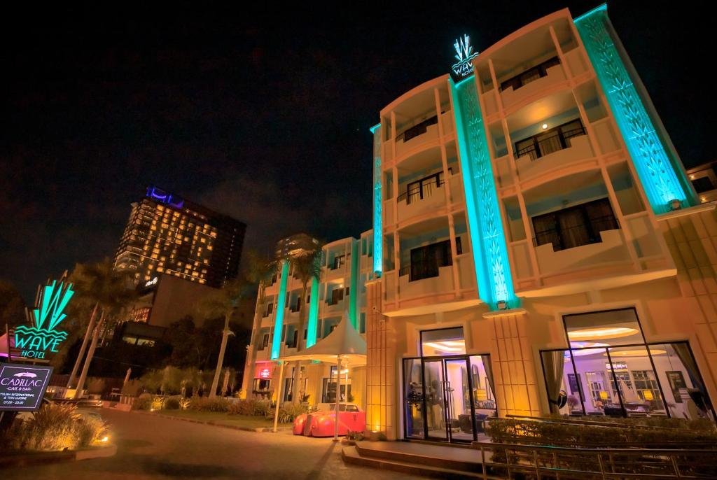 a white building with blue lights on it at night at Wave Hotel Pattaya in Pattaya