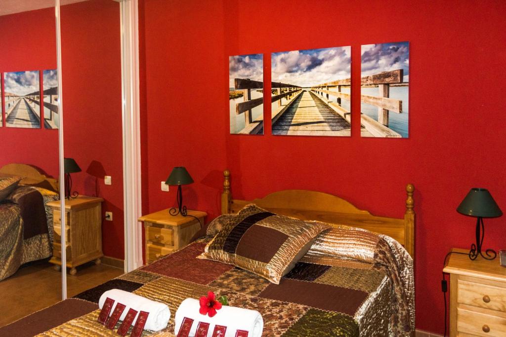 a bedroom with two beds and a bridge painting on the wall at Apartamento Atlanterra Playa in Zahara de los Atunes