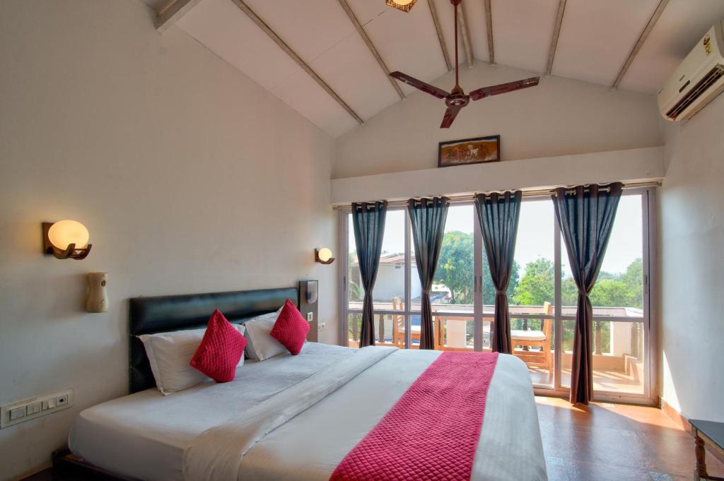 Un dormitorio con una cama grande con almohadas rojas. en Swizel Nook Stay, en Goa