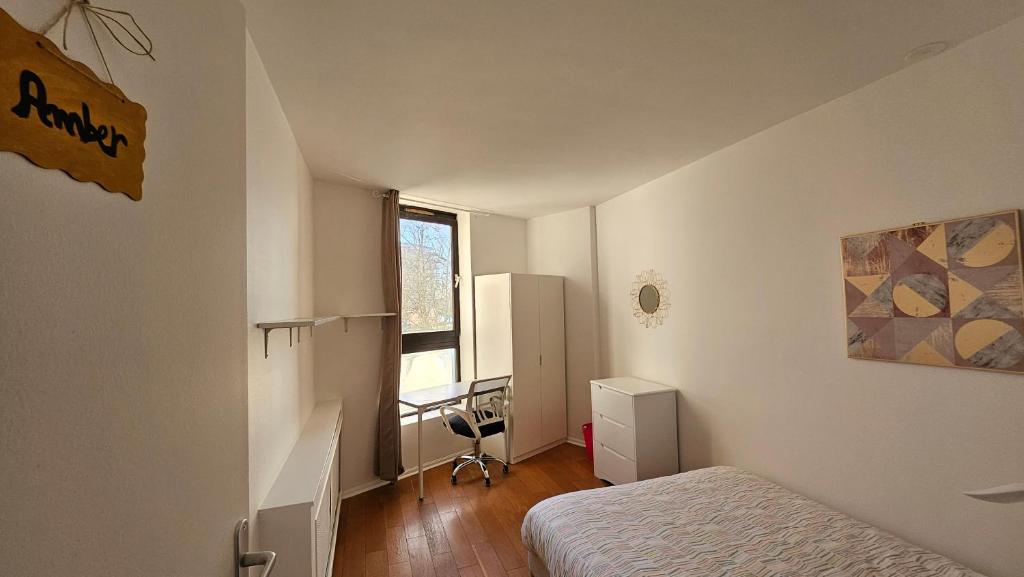 a bedroom with a bed and a desk and a window at Amber room - 20 min to Paris in Créteil