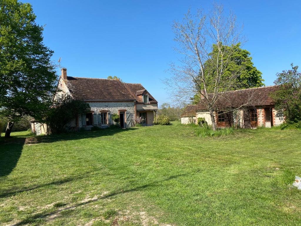 une vieille maison avec une cour d'herbe devant elle dans l'établissement La Clémendière, un paradis caché, à Chailly-en-Gâtinais