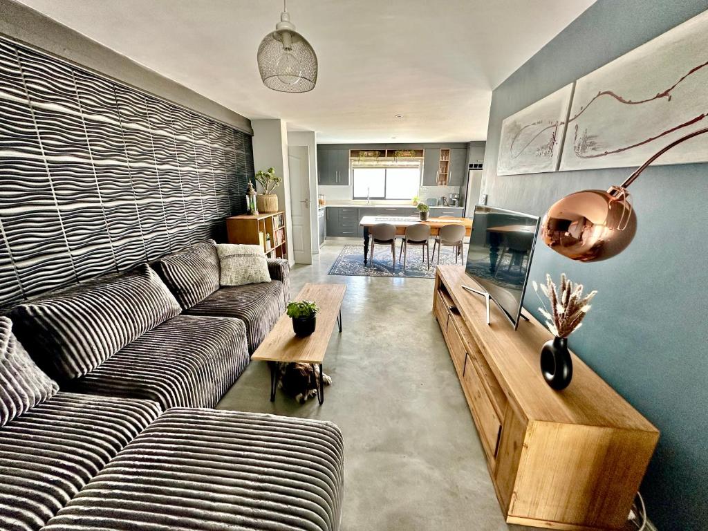 un soggiorno con un divano e un acquario di On Point Guest Cottage a Stompneusbaai
