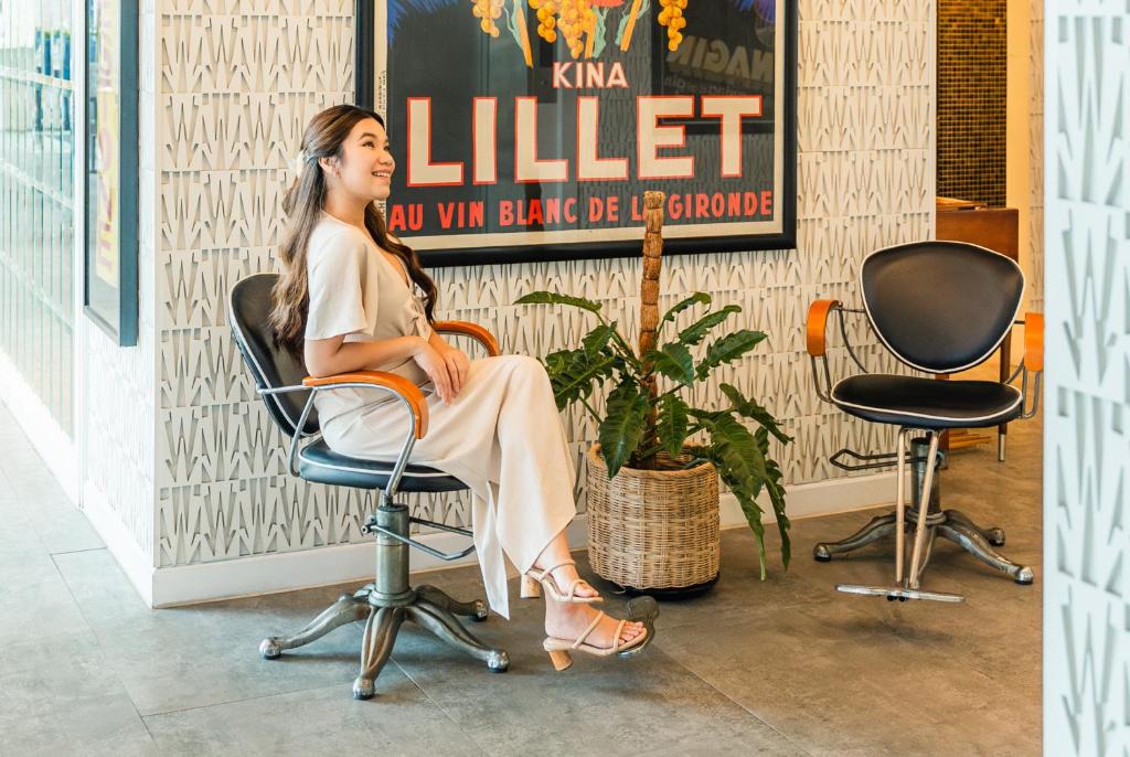 a woman sitting in a chair in a room at Wave Hotel Pattaya in Pattaya