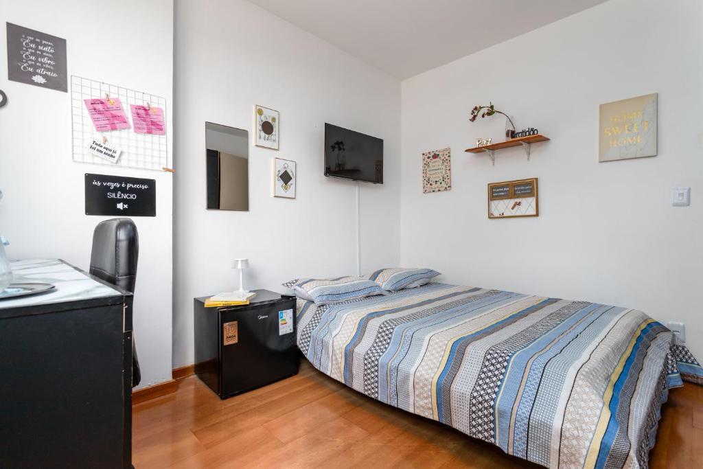a bedroom with a bed in a room with a kitchen at Praia de Icarai a 500m in Niterói