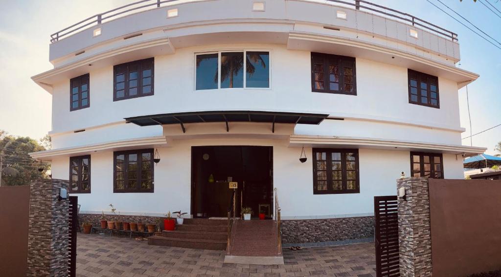 a large white house with a round top at MATHER RAJAGIRI FURNISHED APARTMENTS in Alwaye