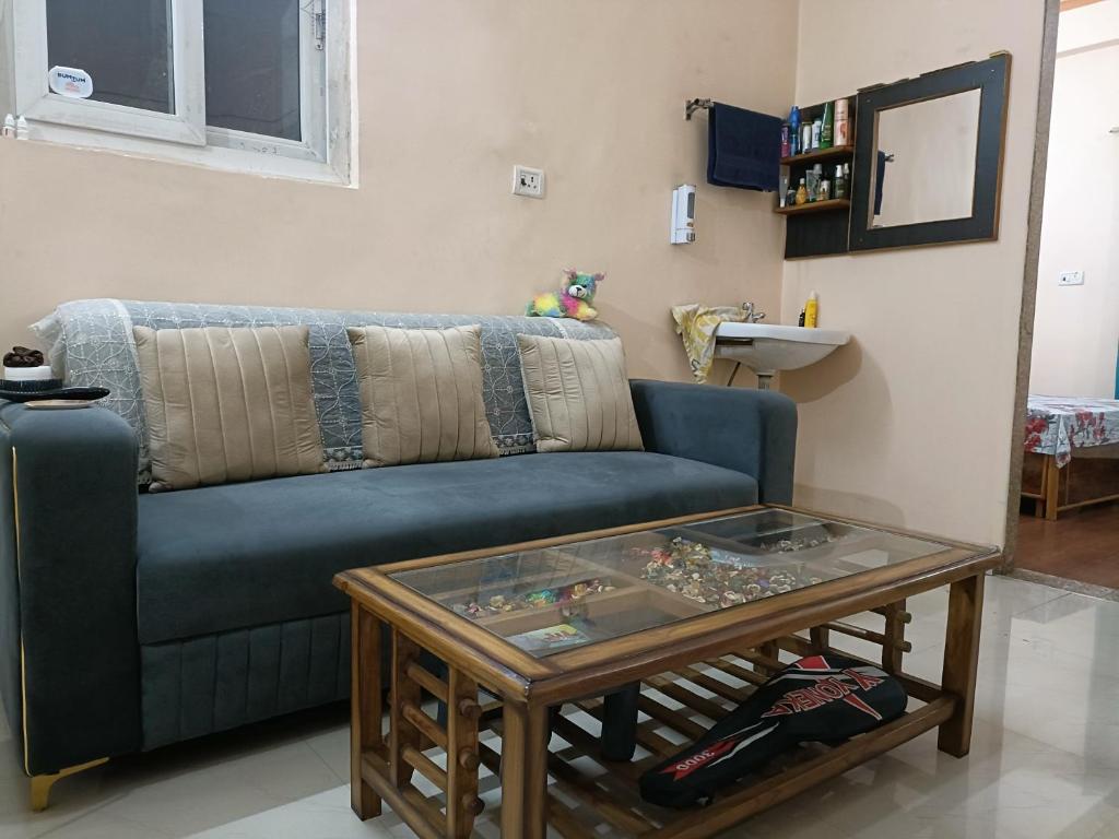 un soggiorno con un divano blu e un tavolo di Shakti HomeStay - Kashi Dham a Varanasi