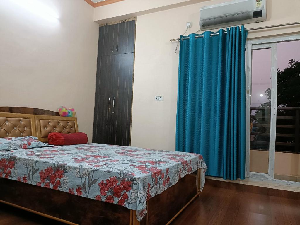 a bedroom with a bed and a blue curtain at Shakti HomeStay - Kashi Dham in Varanasi