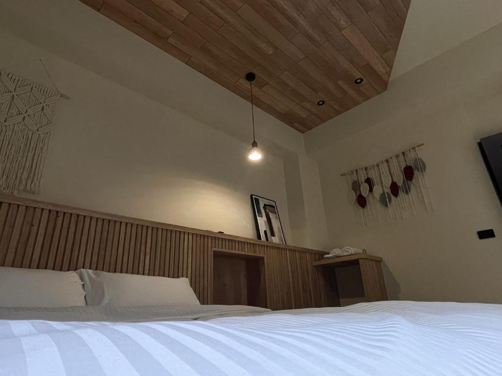 Un dormitorio con una cama blanca con cabecero de madera. en 步步精心, en Zhushan