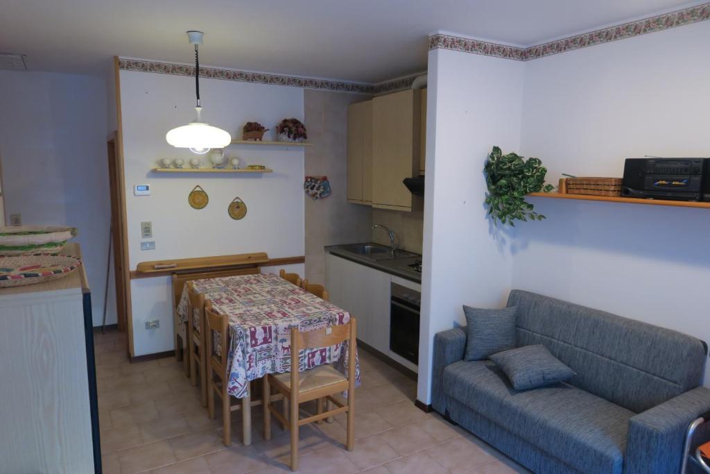 un salon avec une table et un canapé et une cuisine dans l'établissement Appartamento Aurora, à Molina di Ledro