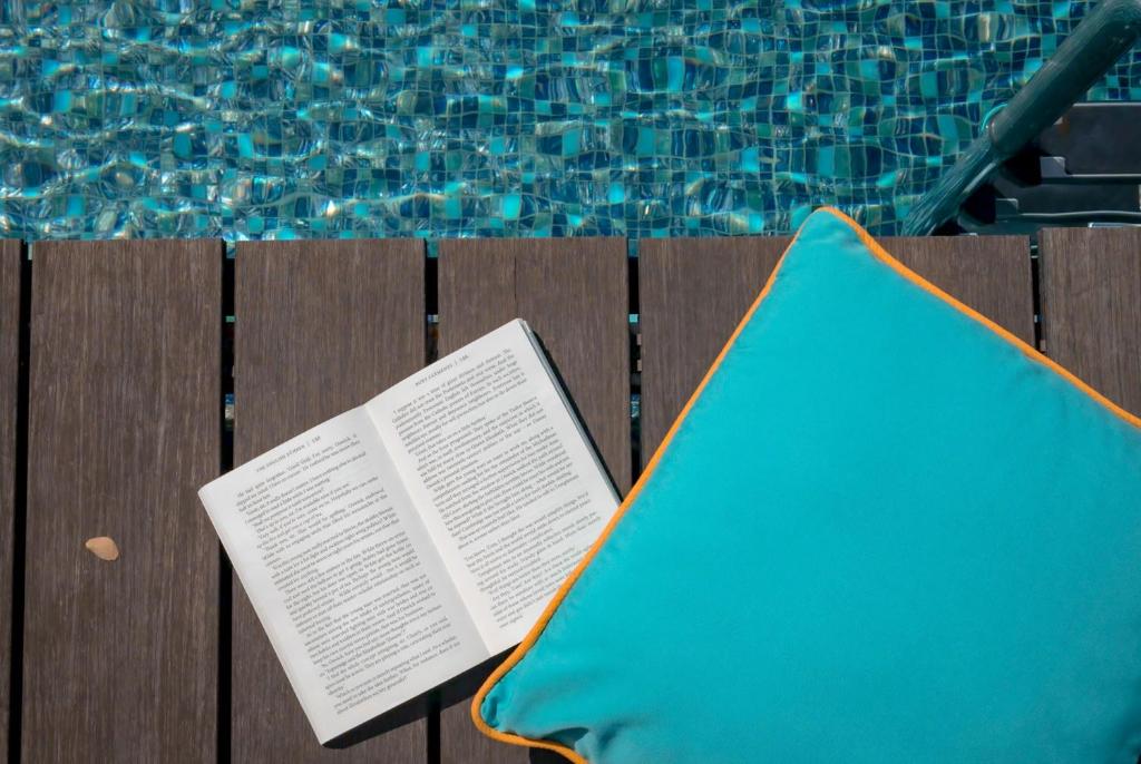 a book sitting on a chair next to a swimming pool at Wave Hotel Pattaya in Pattaya