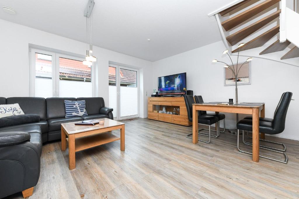 een woonkamer met een bank en een tafel bij Ferienhaus Lüttje Krabbe in Carolinensiel