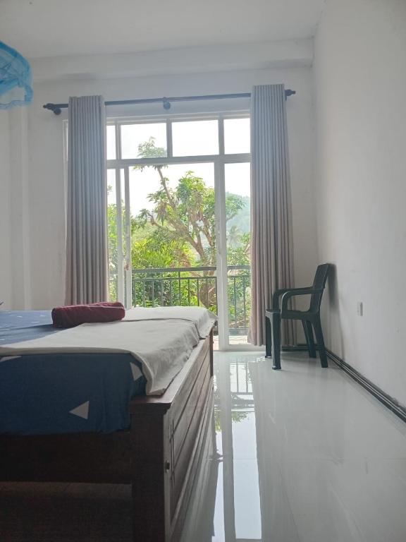 a bedroom with a bed and a window and a chair at Kandy Horizon Homestay in Kandy