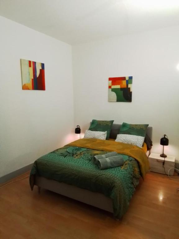 a bedroom with a bed and two paintings on the wall at Appartement studio au cœur de Strasbourg in Strasbourg