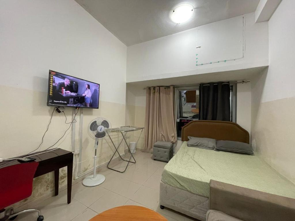 a bedroom with a bed and a flat screen tv at Reflections Ajman-Home Away Home-Best property for stay in Ajman 