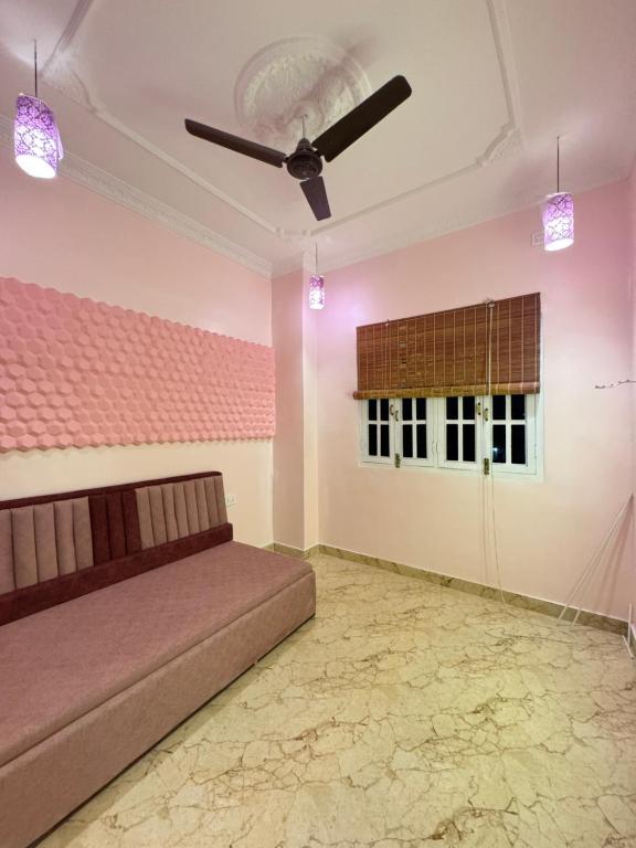ハイデラバードにあるGuest House Single roomのソファと天井ファンのあるリビングルーム