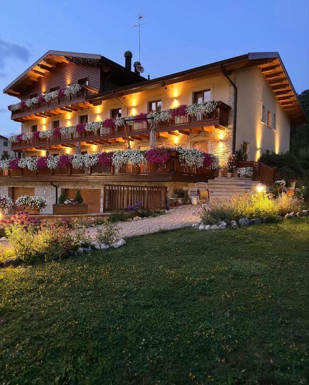 a large building with flowers on the balconies at night at Boutique Hotel Il Riccio - Adults Only in Roccaraso
