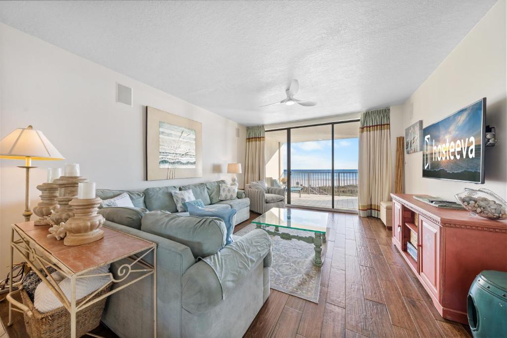 ein Wohnzimmer mit Sofa und Tisch in der Unterkunft White Caps 203 in Orange Beach