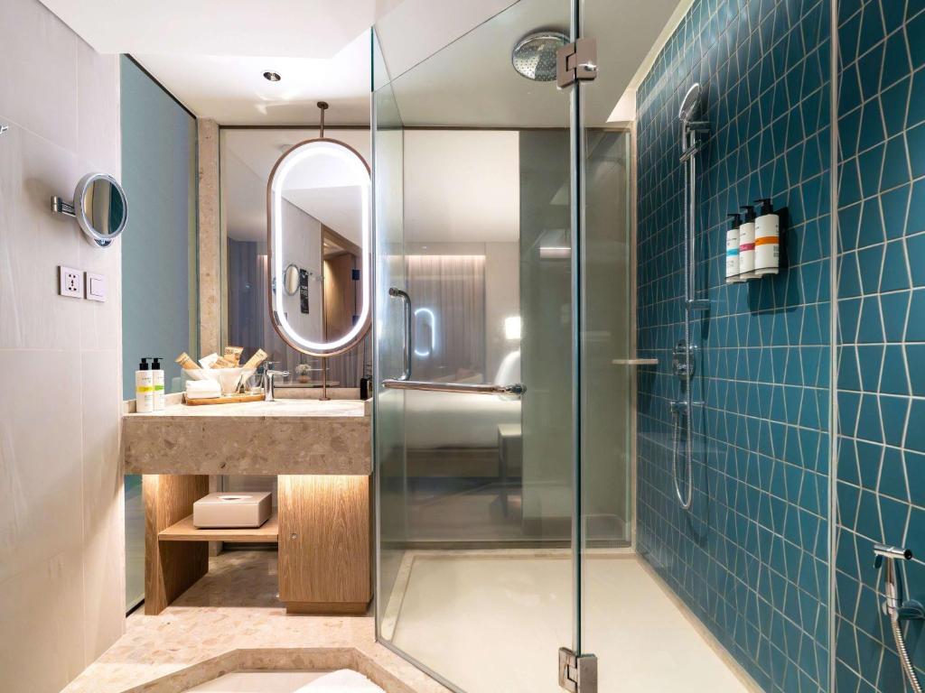 a bathroom with a shower and a sink at Pullman Phuket Karon Beach Resort in Karon Beach