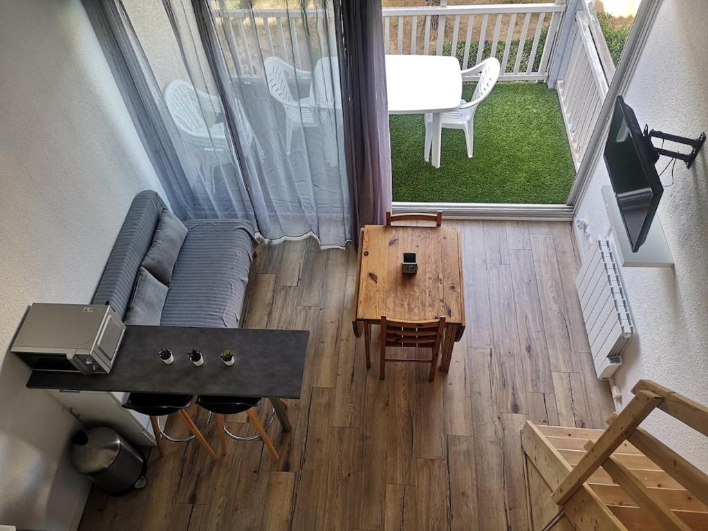 une vue aérienne d'un salon avec un canapé et une table dans l'établissement Le Scarlett - Piscine, parking et proche plage, à Palavas-les-Flots