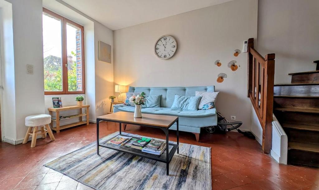 a living room with a blue couch and a table at Maison cosy - Centre - Perche in Tourouvre