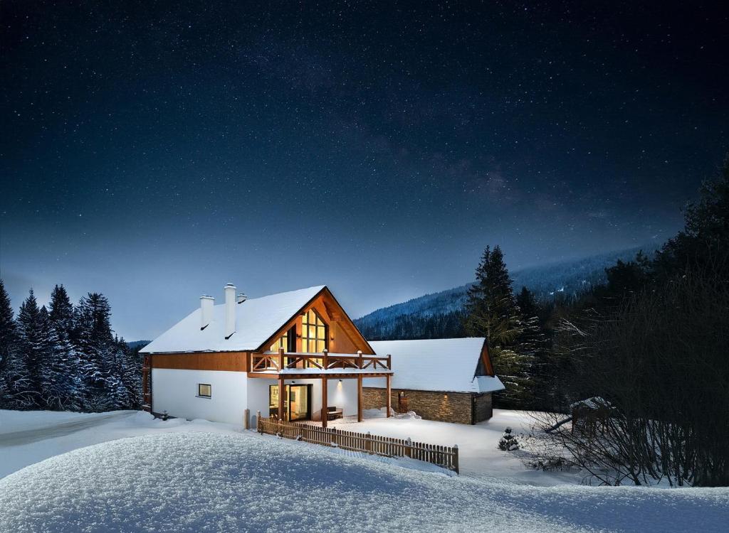 una pequeña casa en la nieve por la noche en Chalet Oasis - Luxury 5-Bedroom Chalet with Panoramic Views, en Huty