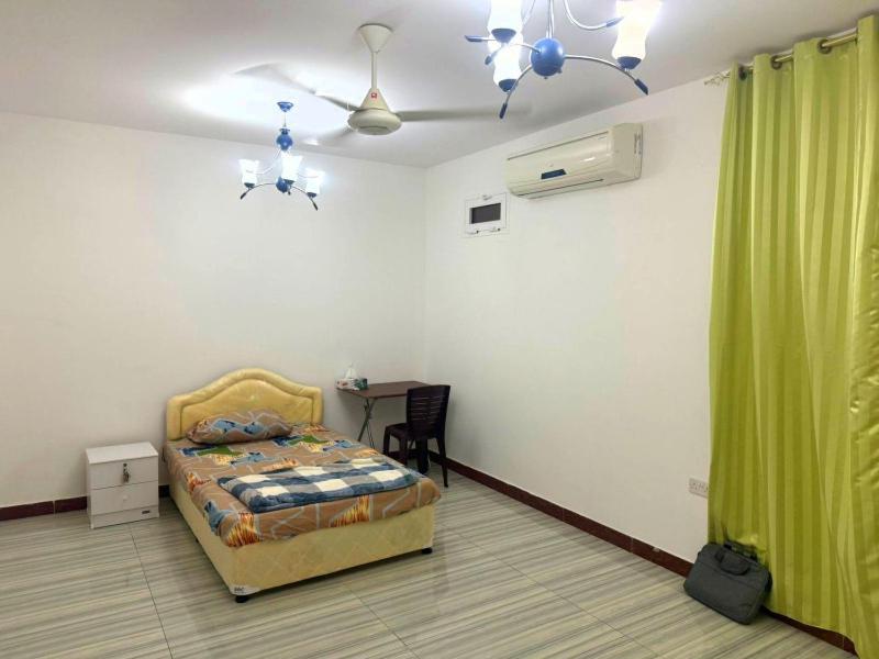 a bedroom with a bed and a green curtain at 1 Separate Bedroom and Attached Bathroom in a shared apartment in Muscat