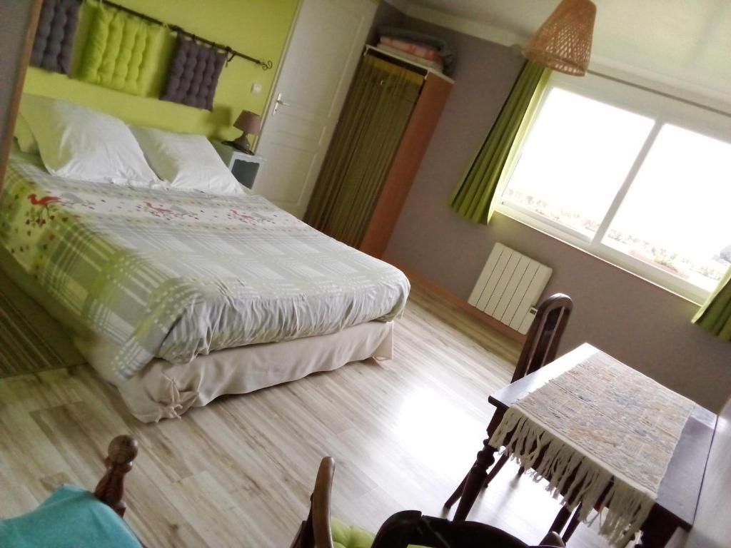 une chambre avec un lit et une fenêtre dans l'établissement Les Marronniers, à Beauficel-en-Lyons