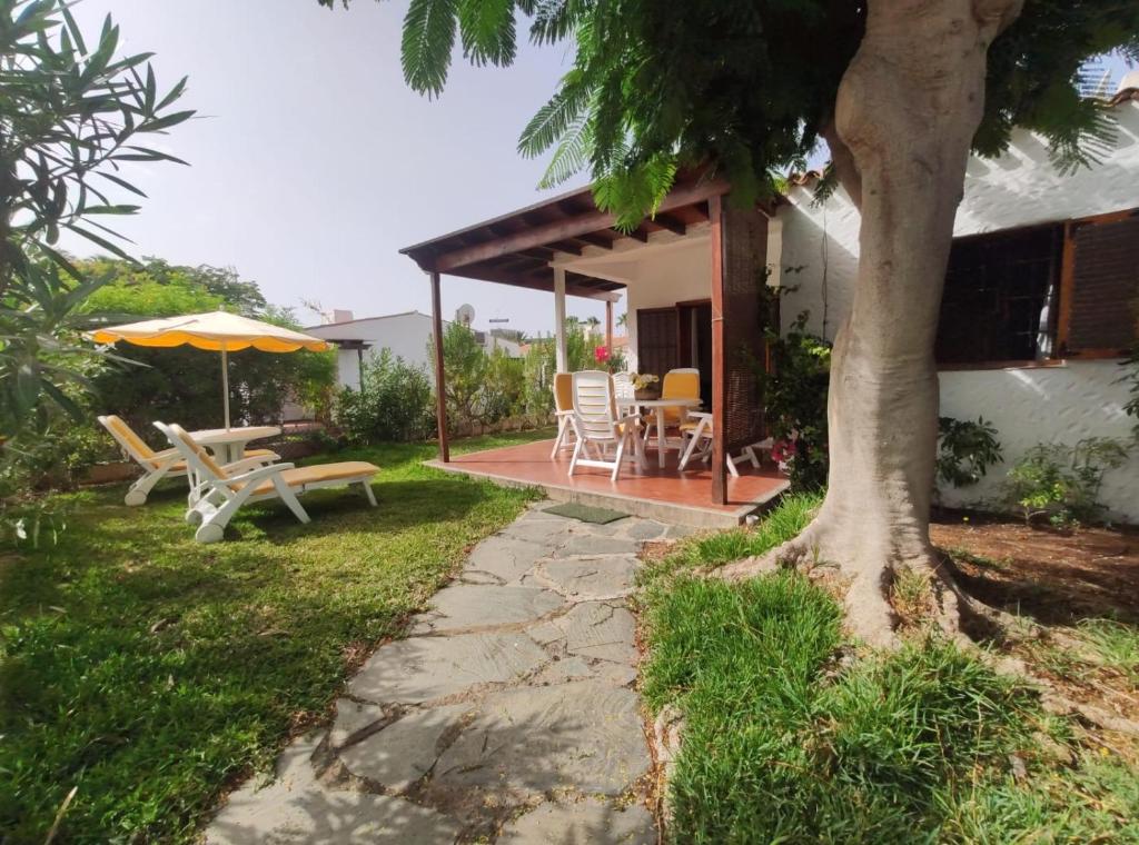 a patio with a table and an umbrella at lovely bungalow with parking in Playa del Ingles