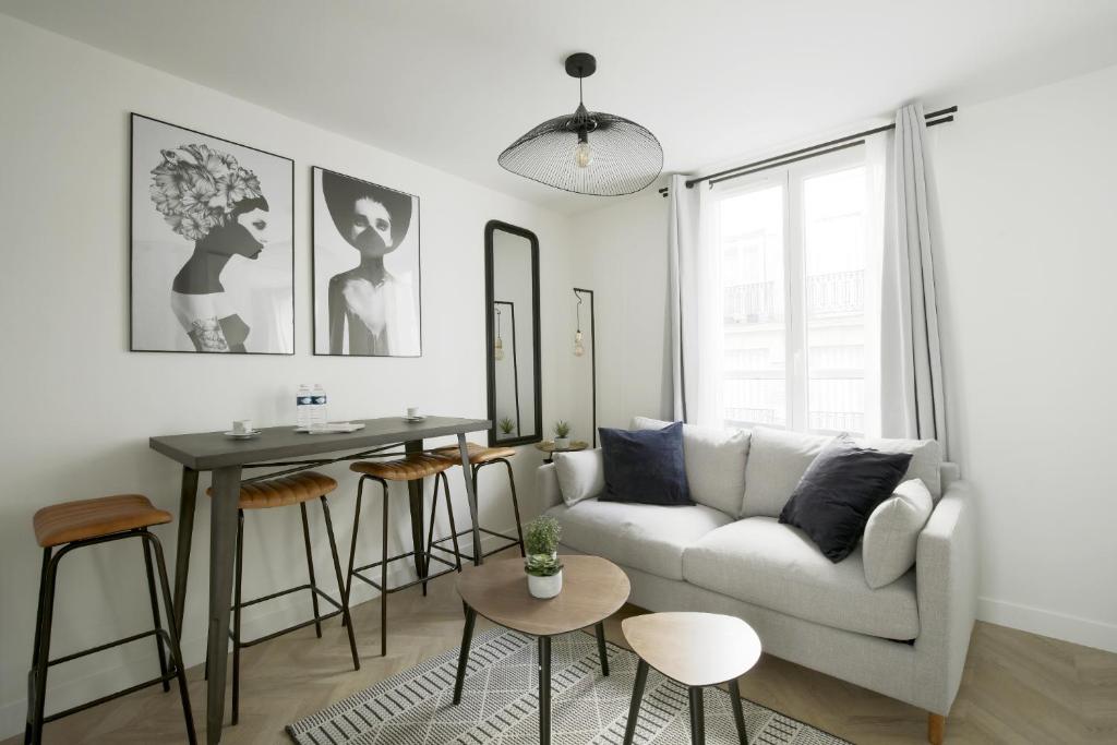 un salon avec un canapé blanc et une table dans l'établissement Chill-out on Private Patio in Vintage Masterpiece, à Paris