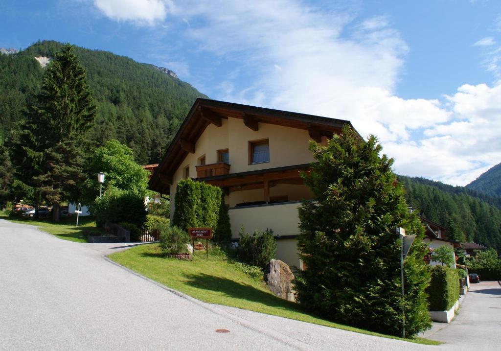 a house on the side of a road with trees at Apartment Peer in Neustift im Stubaital