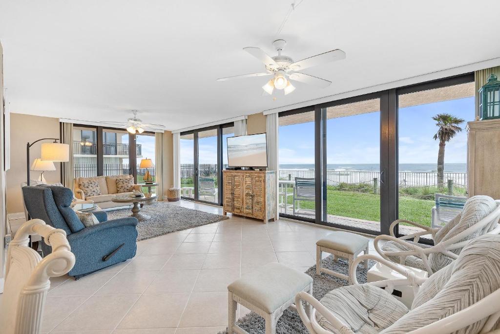 a living room with a blue couch and chairs at Sunrise 109 in New Smyrna Beach