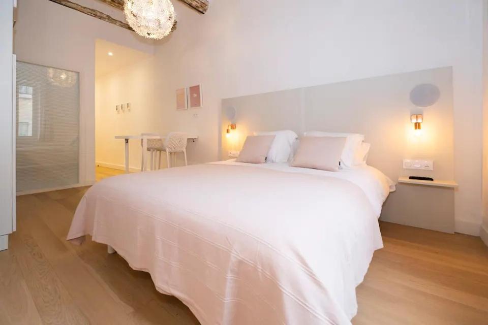 une chambre blanche avec un grand lit blanc avec des oreillers dans l'établissement Design Suite Vieux Port Appartement tout équipé climatisé, à Marseille