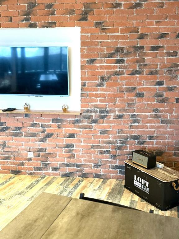 un mur en briques avec une fenêtre et une boîte sur une table dans l'établissement Le Loft d 'Éveux - 2 places de parking, à Éveux