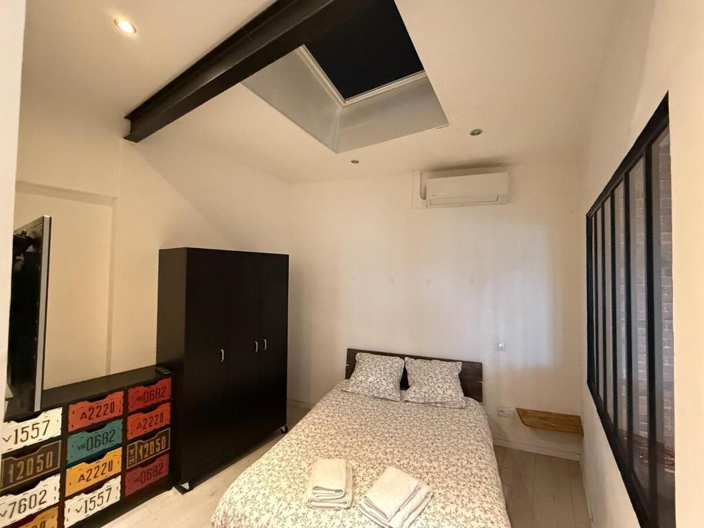 a bedroom with a bed and a black cabinet at Le Loft d 'Éveux - 2 places de parking in Éveux