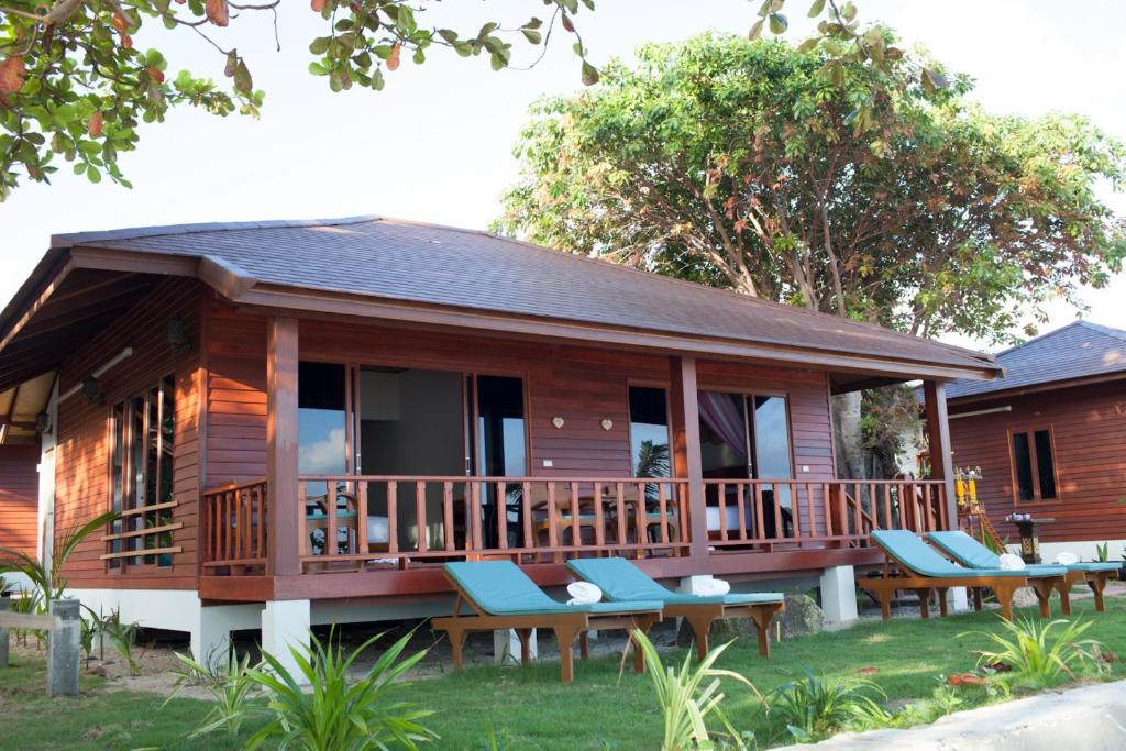 a cabin with picnic tables and chairs in front of it at PingChan Koh Phangan Beachfront Resort in Thong Nai Pan Yai