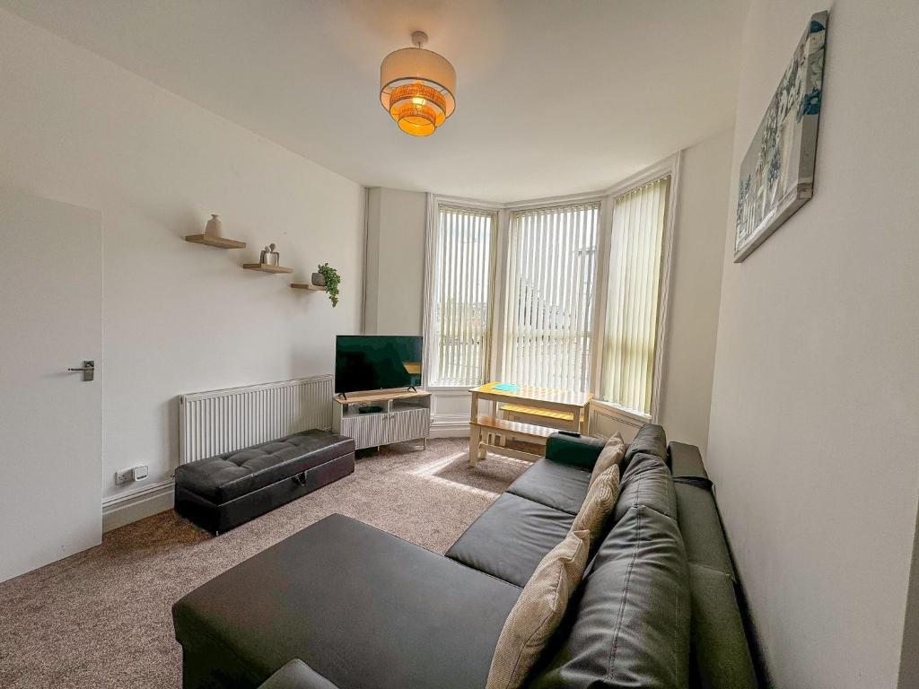 a living room with a couch and a flat screen tv at Cherry Property - Pear Suite in Blackpool