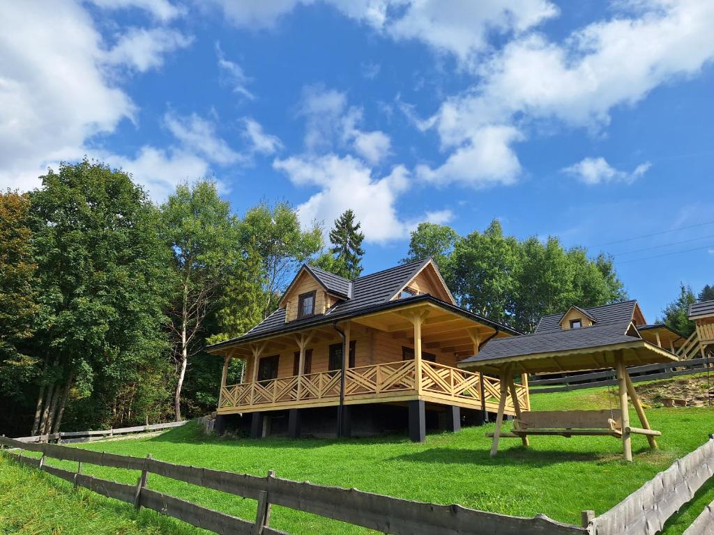 a log house on a hill with a fence at Domek w Klisiówkach in Ujsoły